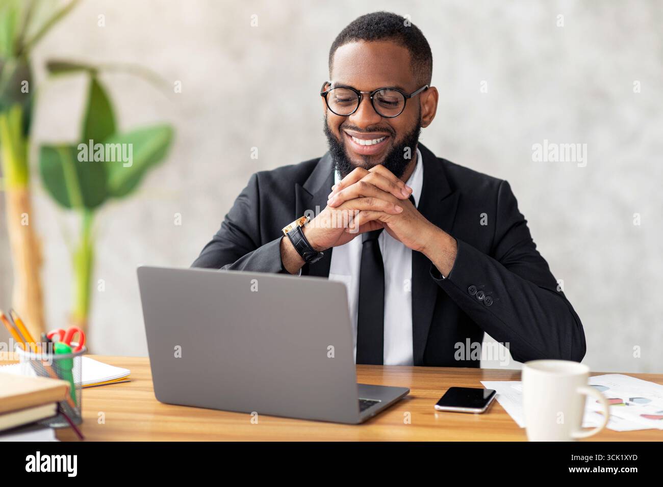 Smiling black man watching video on computer Stock Photo
