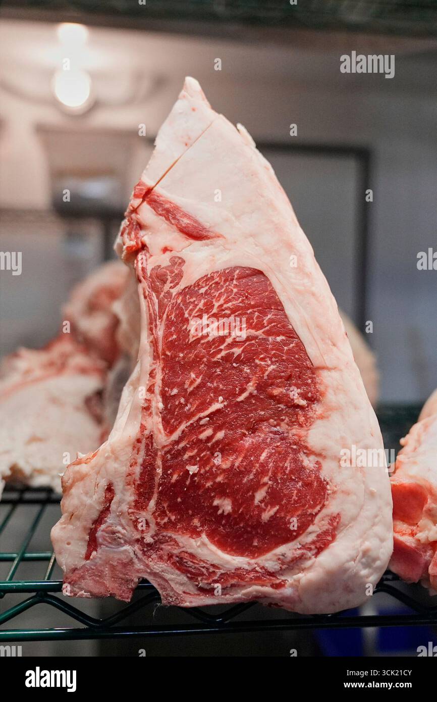 Large primal cuts of beef sit on a rack in a cooler at Deep Cuts ...