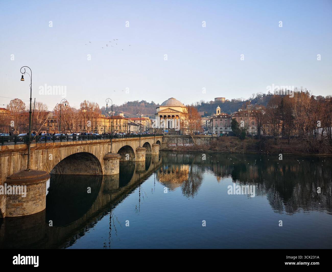 A picturesque view of the Ponte Vittorio Emanuele I spanning the Po River in Turin, Italy. The photo highlights the stone arches of the bridge and the - Smartphone Captured Stock Image