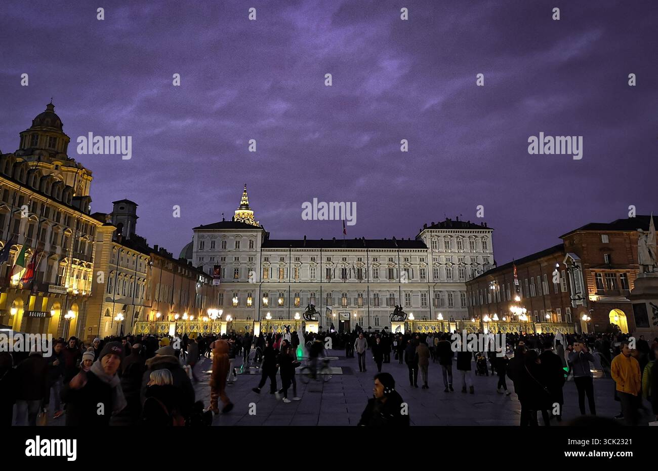 A wide-angle shot of a lively crowd in Piazza Castello in Turin, with the majestic Palazzo Reale dominating the background. The image captures the his - Smartphone Captured Stock Image