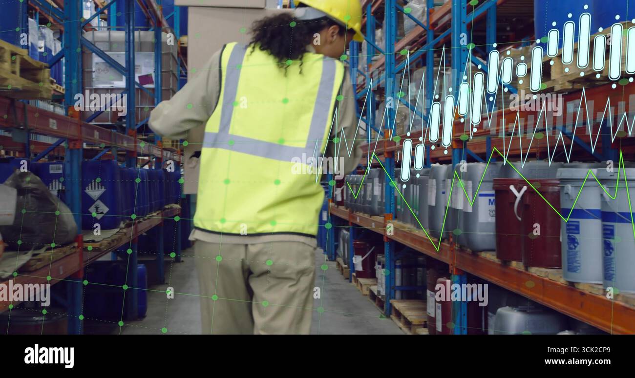 Inspecting worker wearing yellow vest walking warehouse aisle with ...