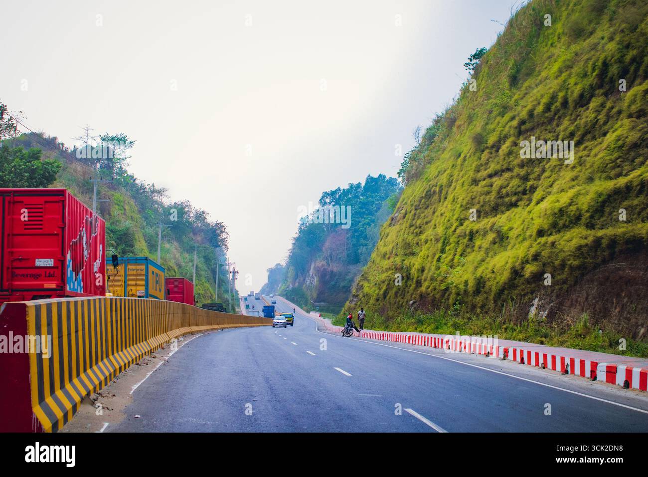 Bayezid link road highway passing through lush green hills with trucks, cars, and motorcycles, showcasing a blend of modern roadways and natural beaut Stock Photo