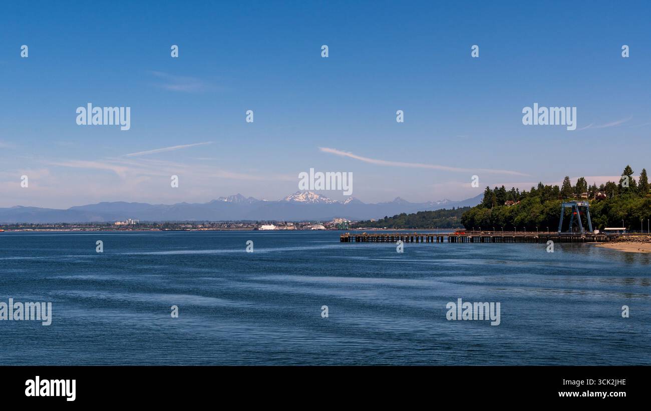 Mukilteo, Washington / USA – 10 JUN 2025: The Cascade Mountains are seen across the water from the Mukilteo ferry dock. Stock Photo
