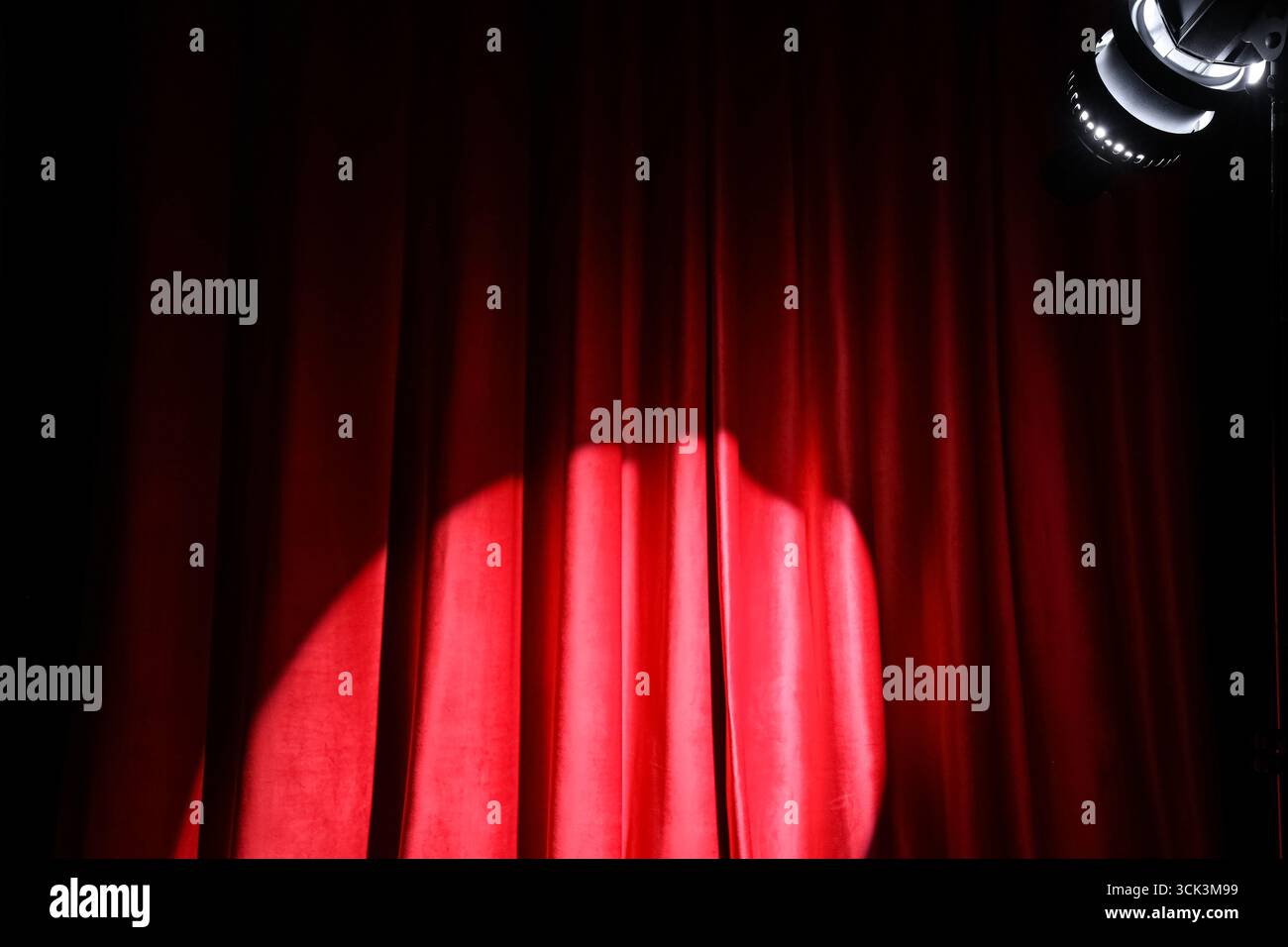 Shining spotlight on red curtain Stock Photo
