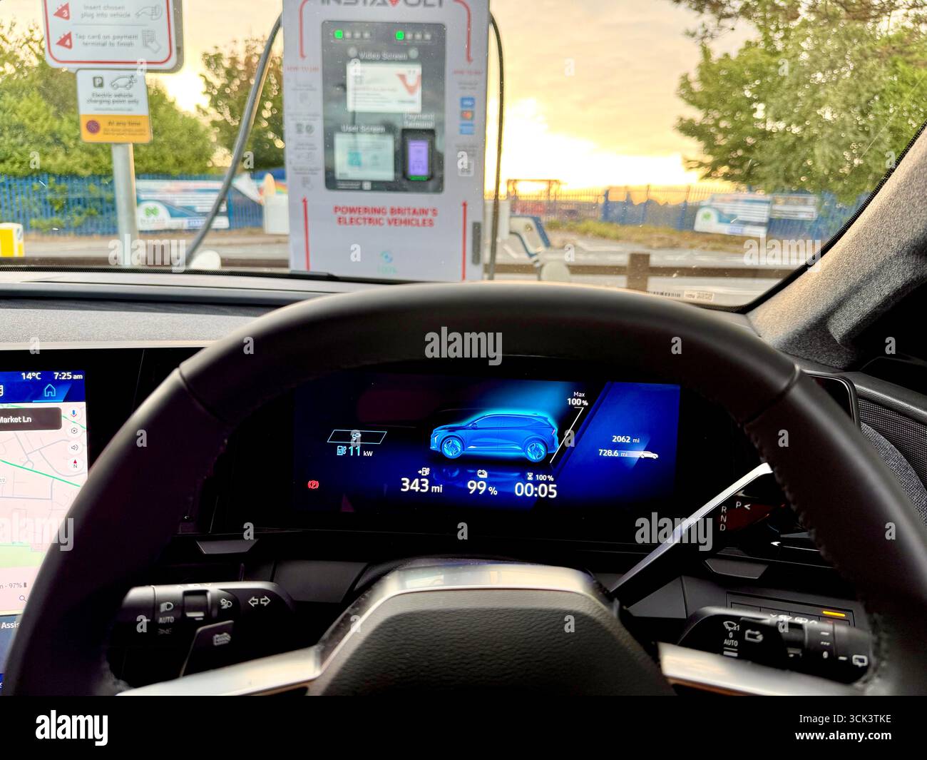 An electric car dashboard displaying 99% charged connected to a rapid EV charger point in the U.K. Stock Photo