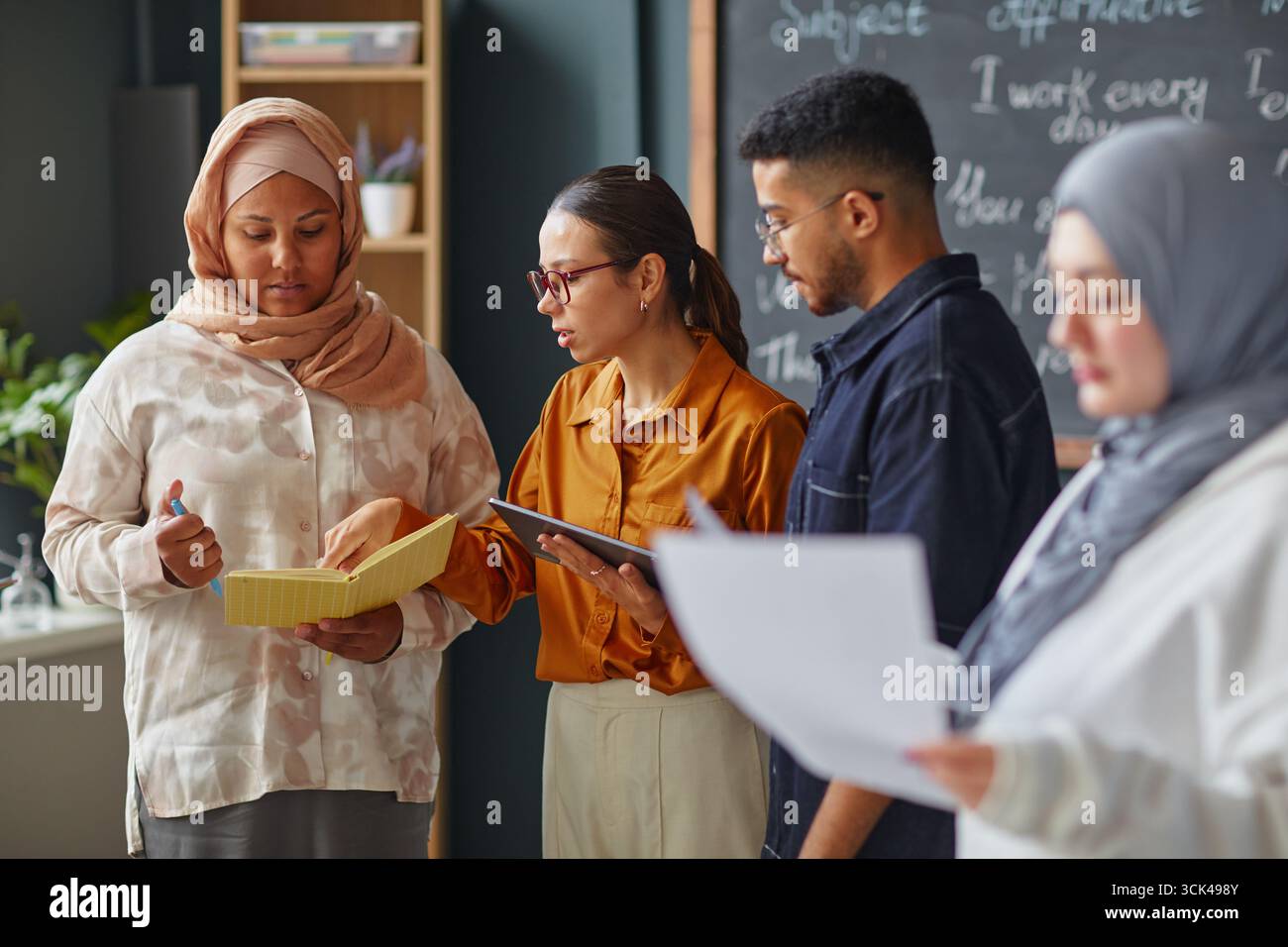 Multiethnic Young Adults Collaborating during Language School Group Activity Stock Photo