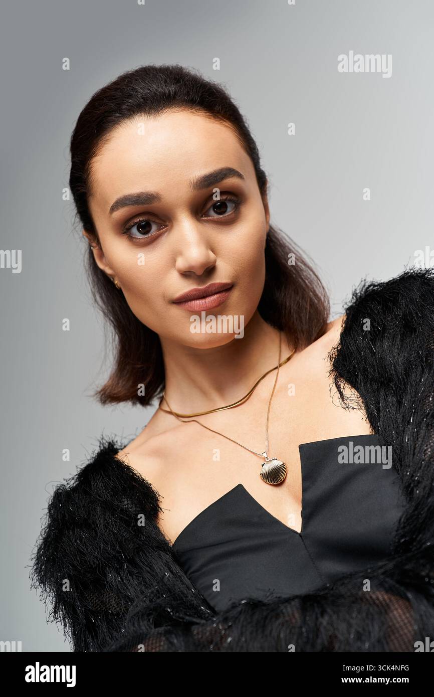 Brunette model poses confidently in a fashionable black ensemble, exuding elegance. Stock Photo