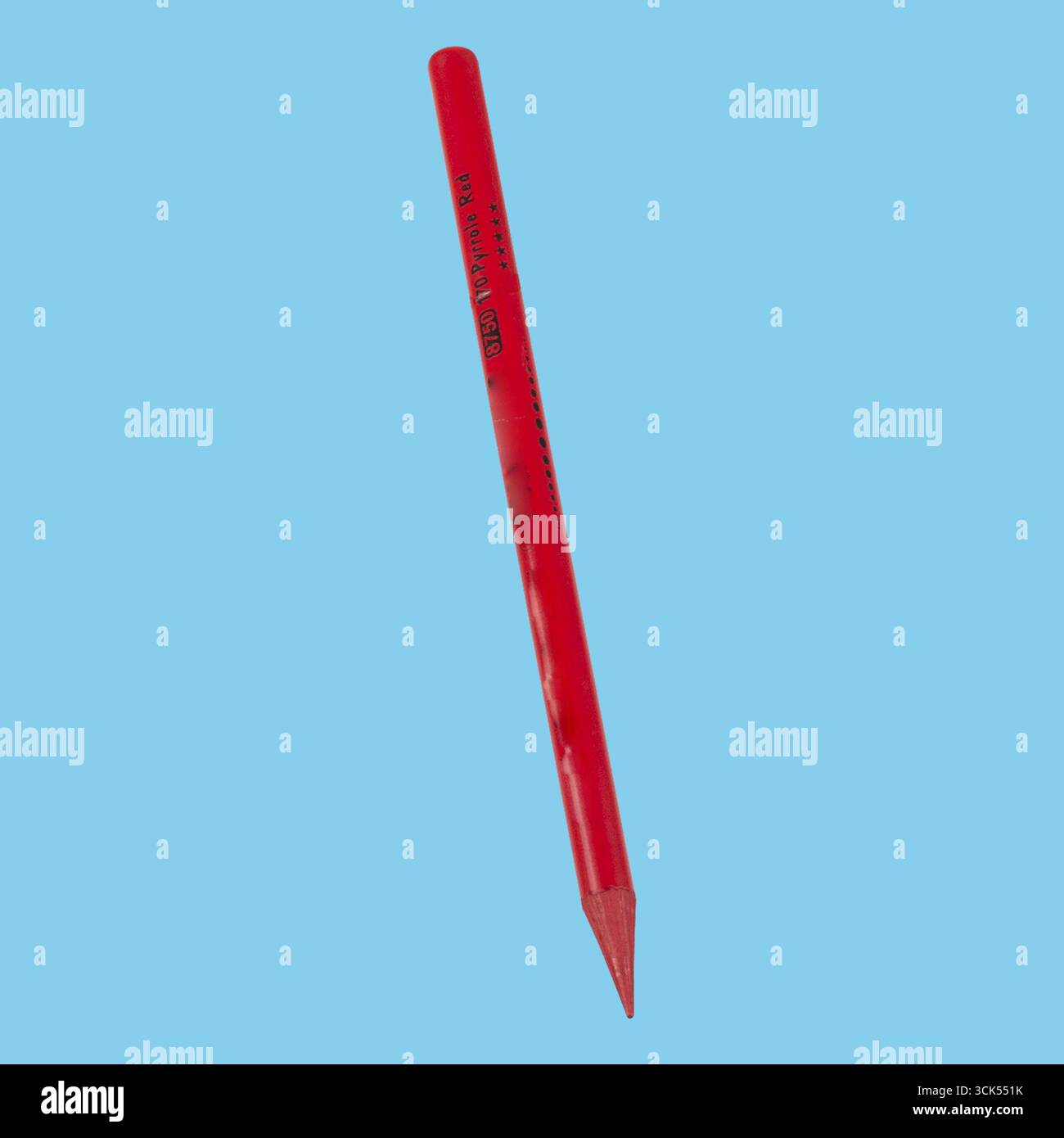 A red pencil with a sharpened tip, commonly used for writing or drawing. Stock Photo
