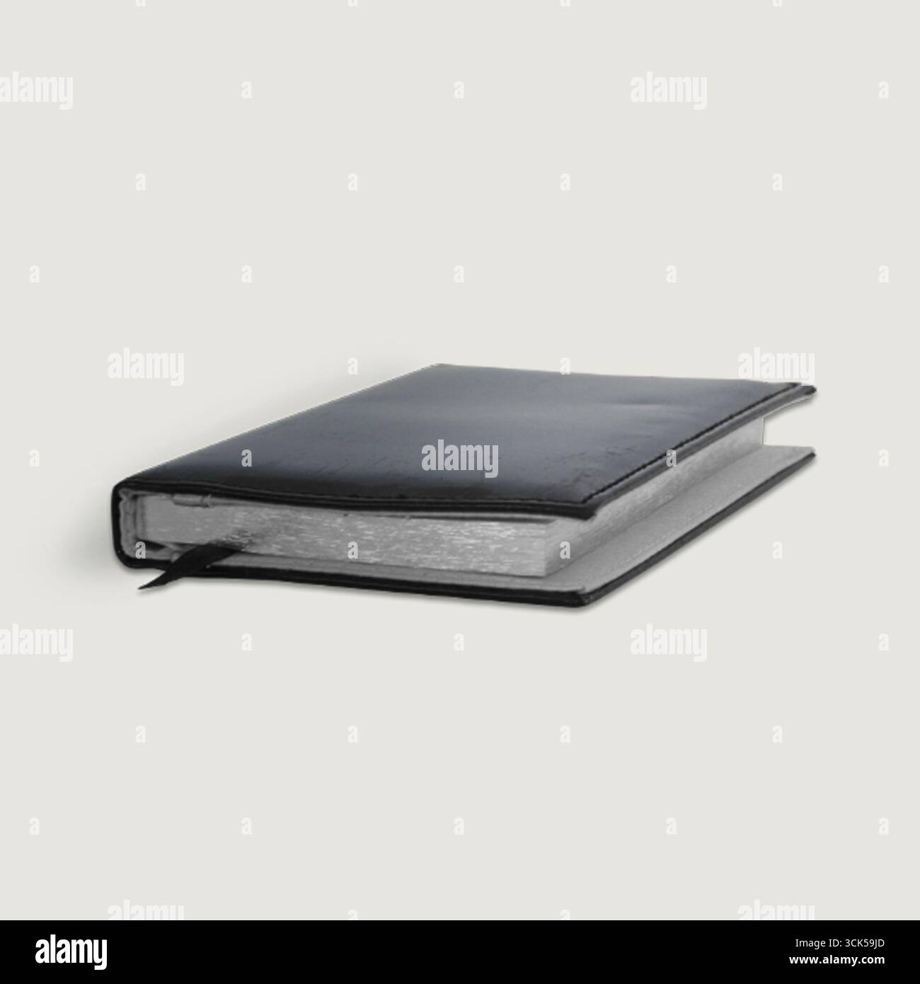 A closed black notebook with a textured cover, ideal for journaling or note-taking. Stock Photo