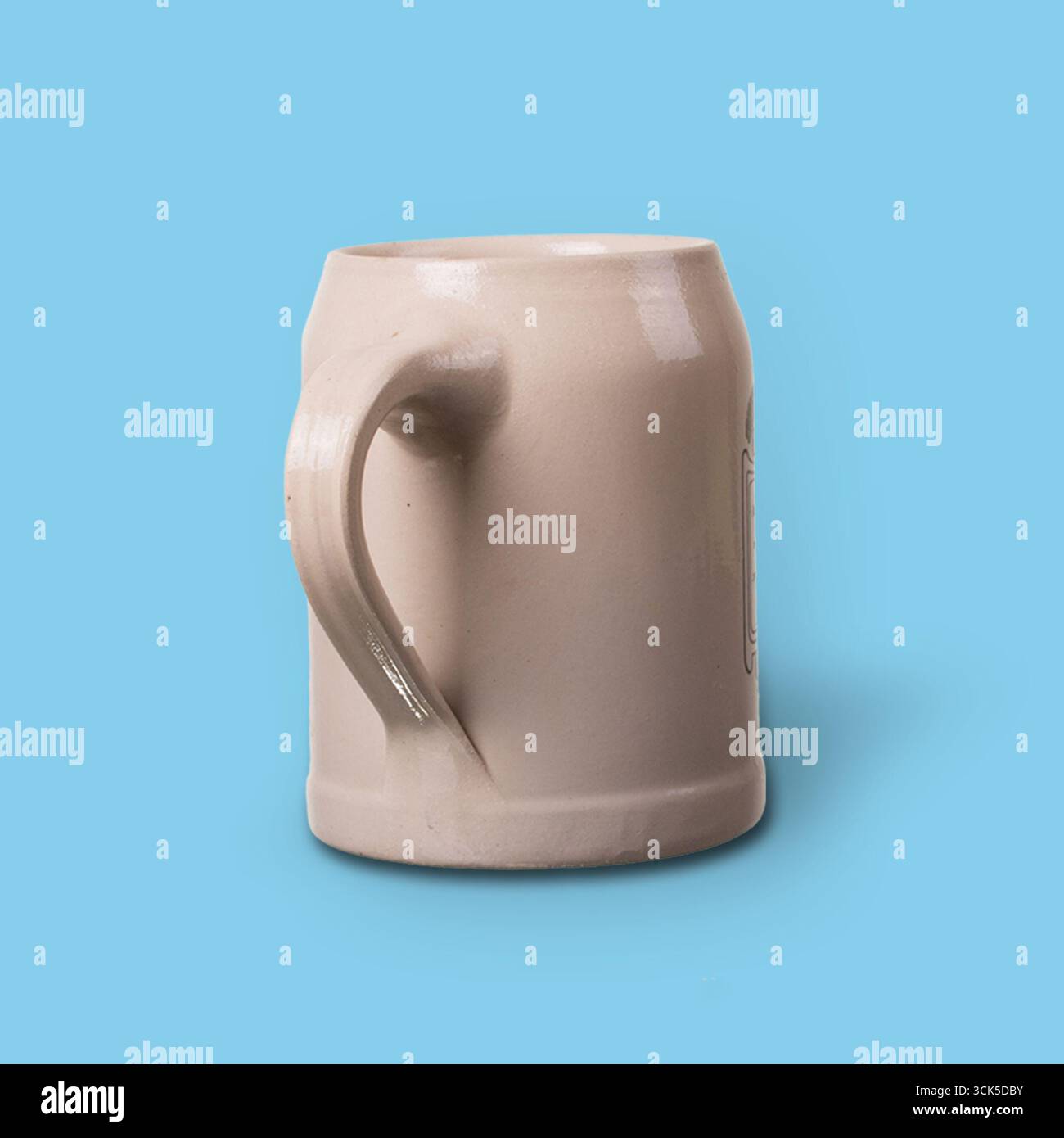 A simple ceramic mug with a handle, designed for holding beverages. Stock Photo
