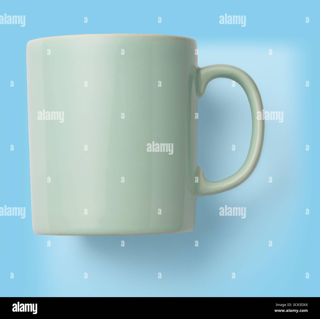 A simple mint-green ceramic mug with a handle, designed for holding beverages. Stock Photo