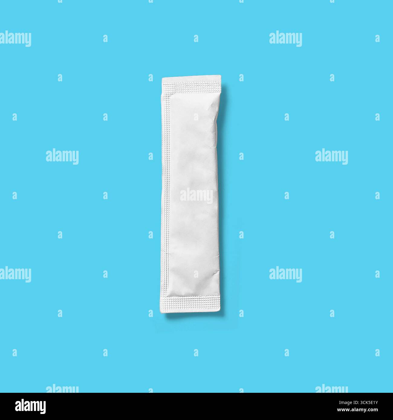 A small, unmarked white packet, likely containing a single-use item or substance. Stock Photo