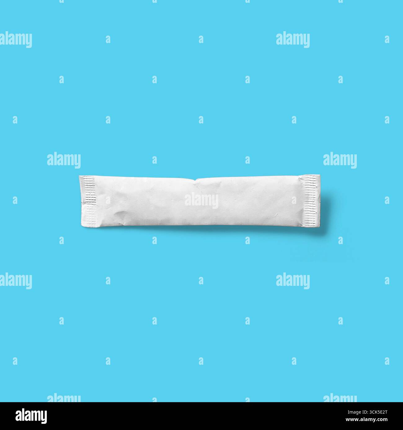A plain white sealed packet, possibly containing a powdered substance or condiment. Stock Photo