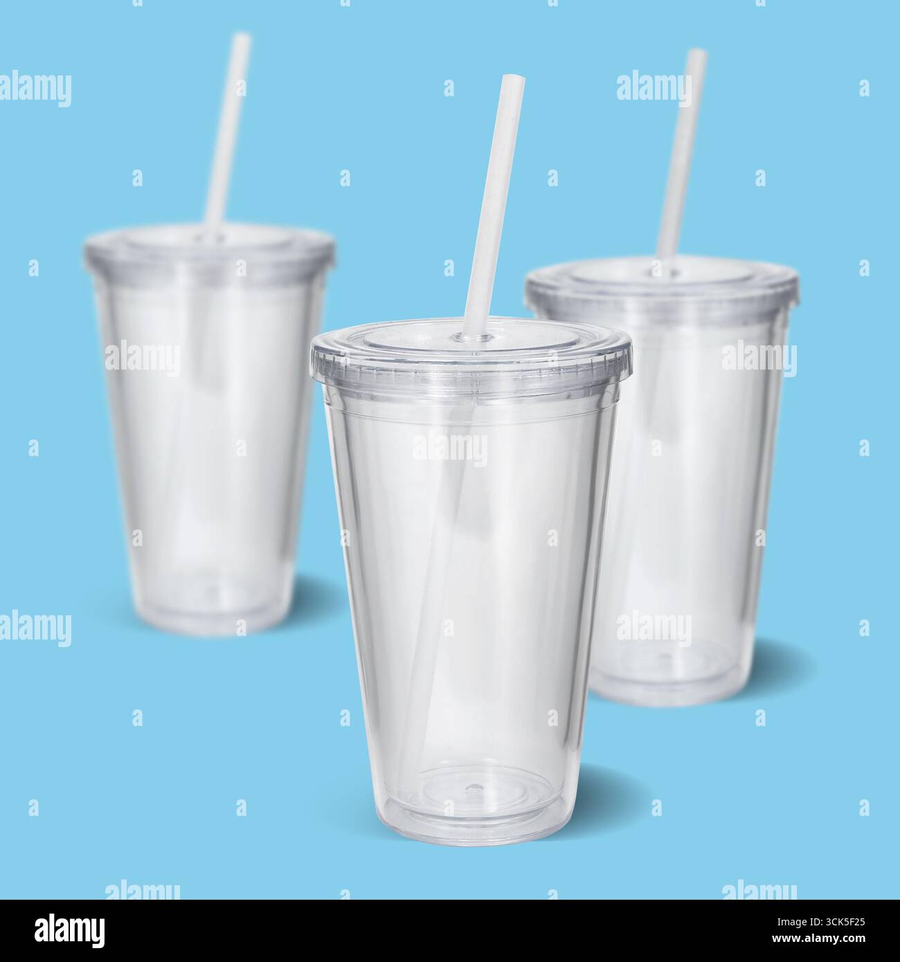Three clear plastic cups with straws, ideal for beverages. Stock Photo