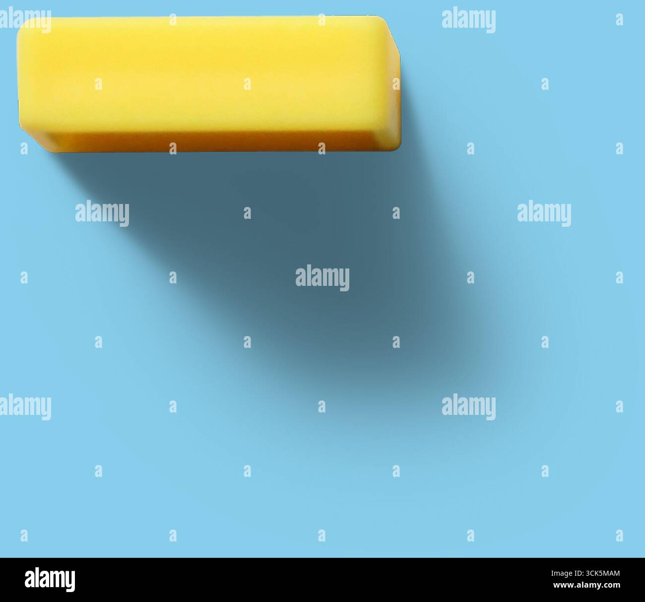 A simple yellow rectangular eraser, commonly used for correcting pencil marks on paper. Stock Photo