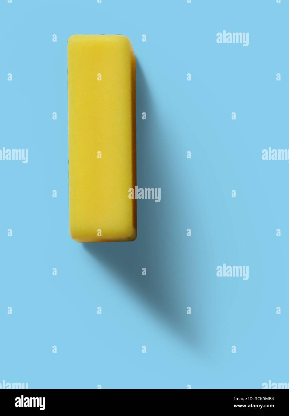 A yellow rectangular eraser, commonly used for correcting pencil marks on paper. Stock Photo