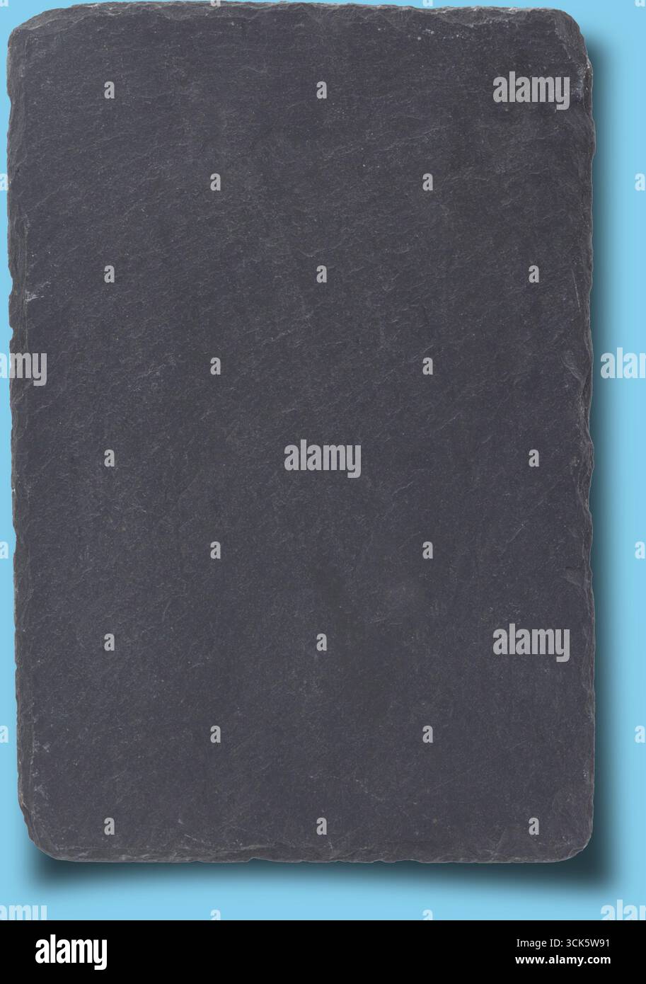 A flat, rectangular slate stone with a smooth surface, often used for serving food or as a decorative item. Stock Photo