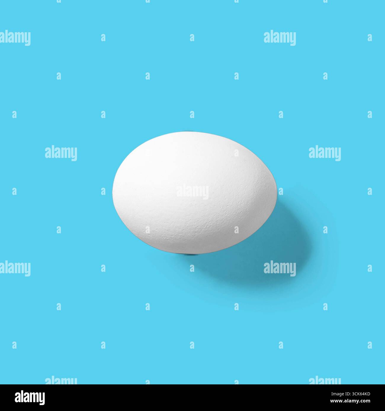 A simple, smooth white egg on a plain background, highlighting its shape and texture. Stock Photo