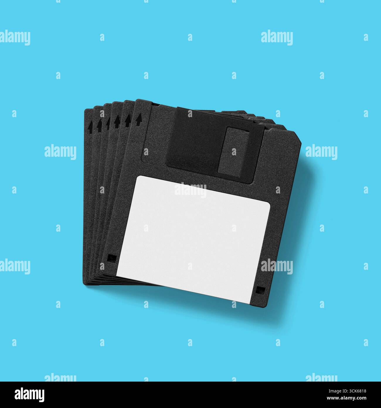 A stack of five black floppy disks, commonly used for data storage in older computers. Stock Photo