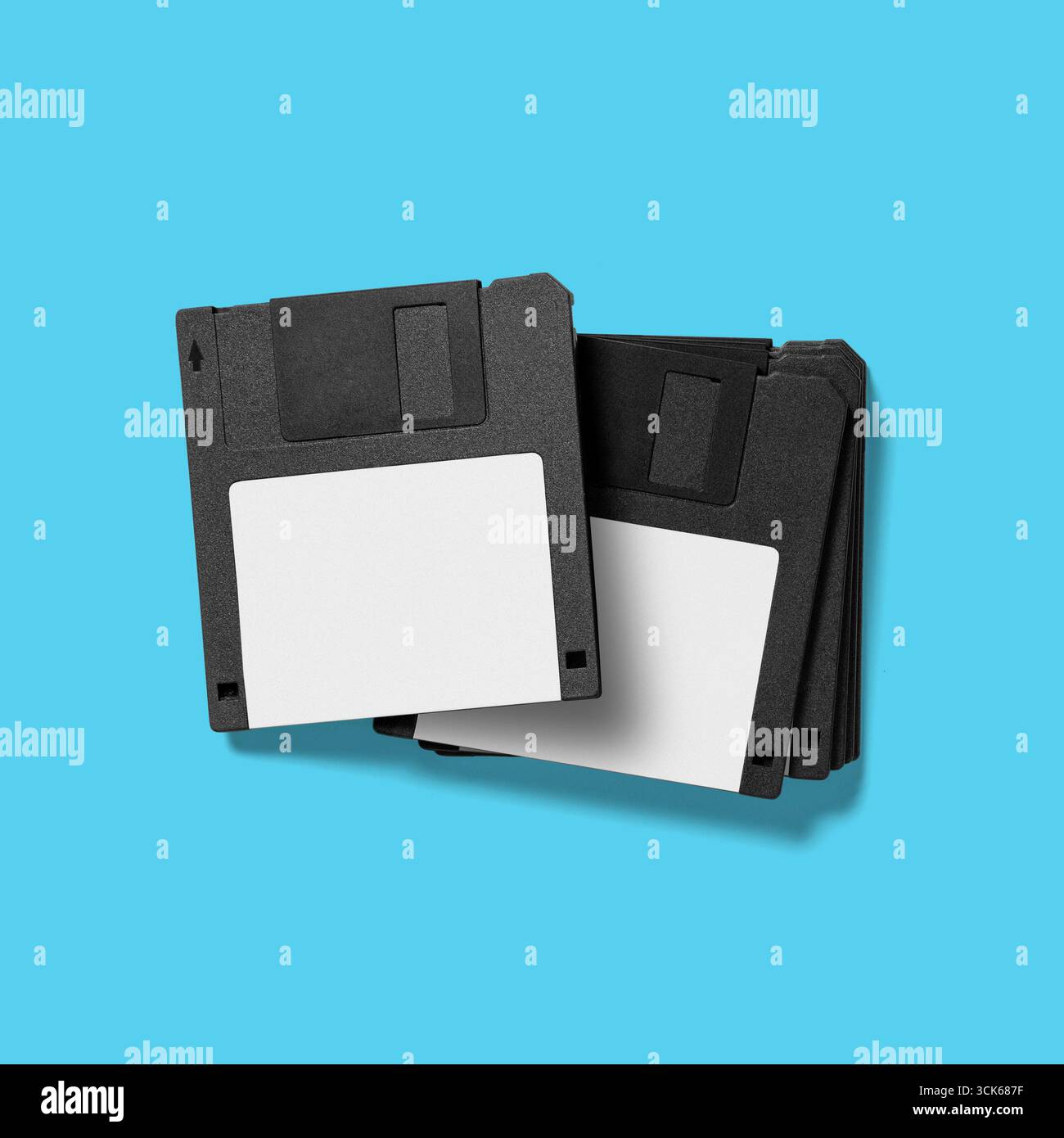 A stack of black floppy disks, commonly used for data storage in older computer systems. Stock Photo