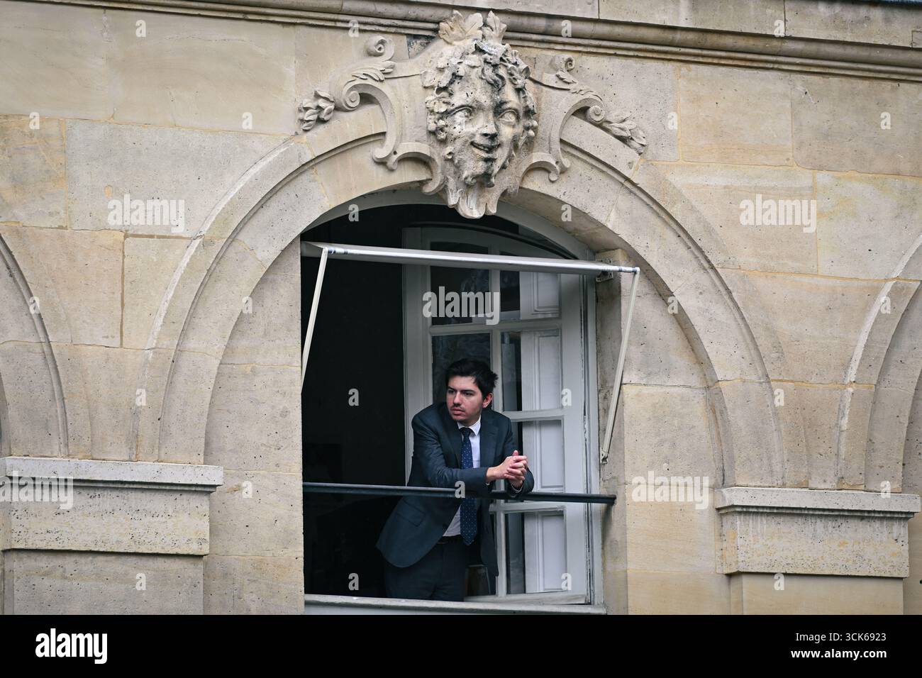 Hand Over Window An employee looks from a window at a handover ceremony at the Hotel de ...