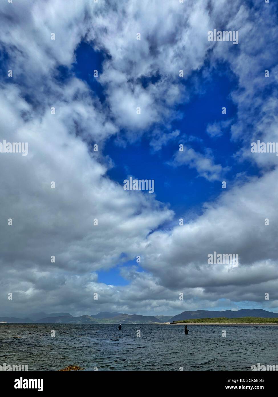 Anglers fishing in Castlemaine harbour SPA under a dramatic sky - Smartphone Captured Stock Image