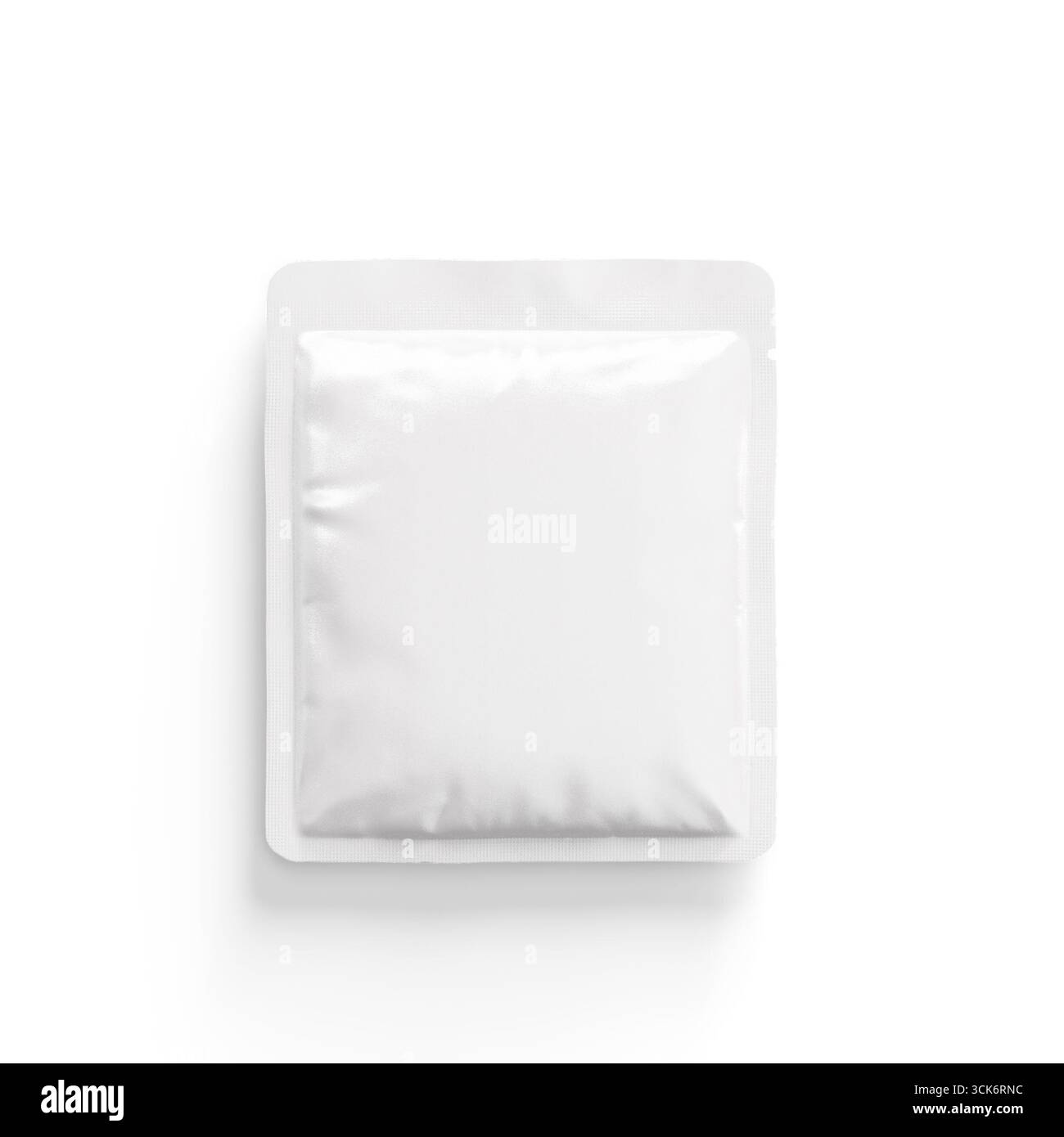 A plain white packet, likely containing a powder or condiment, designed for single-use convenience. Stock Photo
