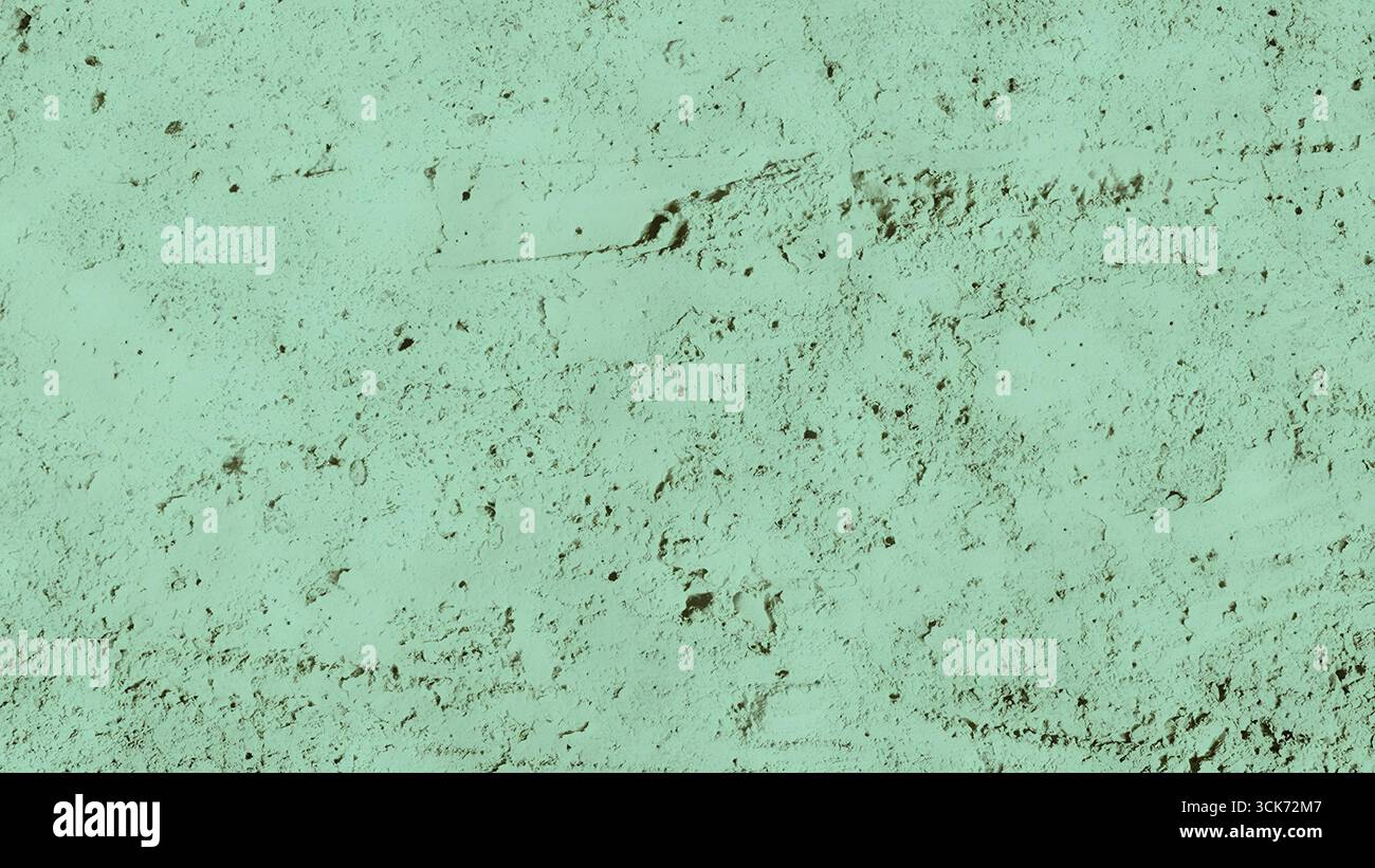 A textured surface featuring a muted green hue, resembling rough concrete or plaster. Stock Photo