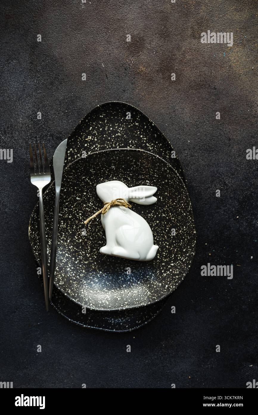 Easter festive table setting for holiday dinner on dark concrete background with copy space Stock Photo