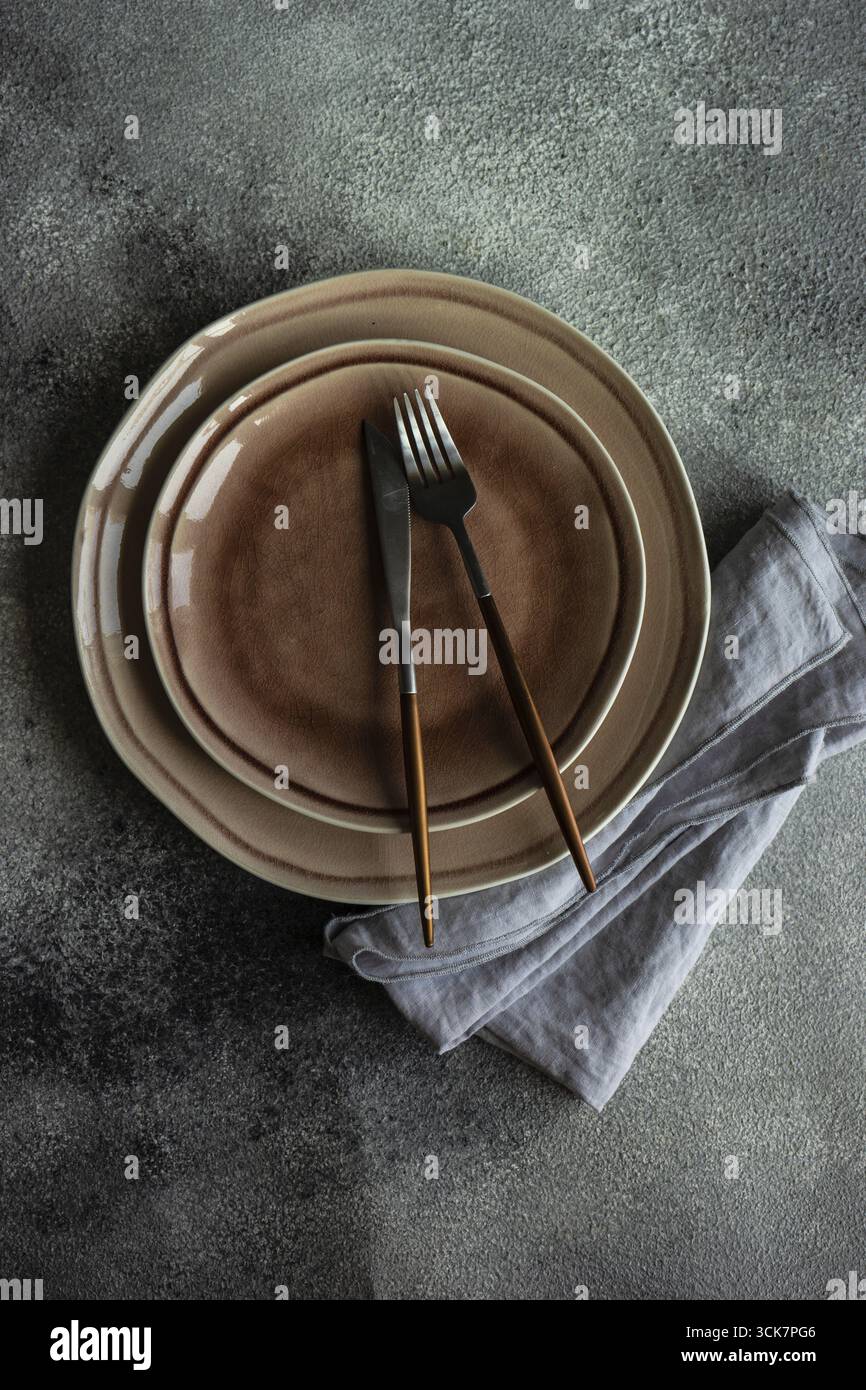 Cutlery set with empty plates on stone background with copy space Stock Photo