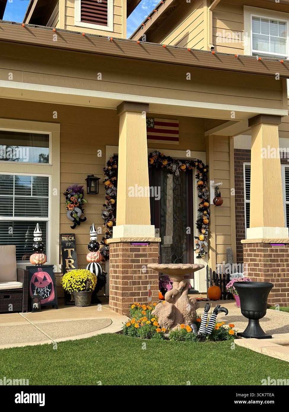 Suburban house decorated with pumpkins, garlands, and Halloween ornaments, including “Trick or Treat” signs and playful garden details. - Smartphone Captured Stock Image