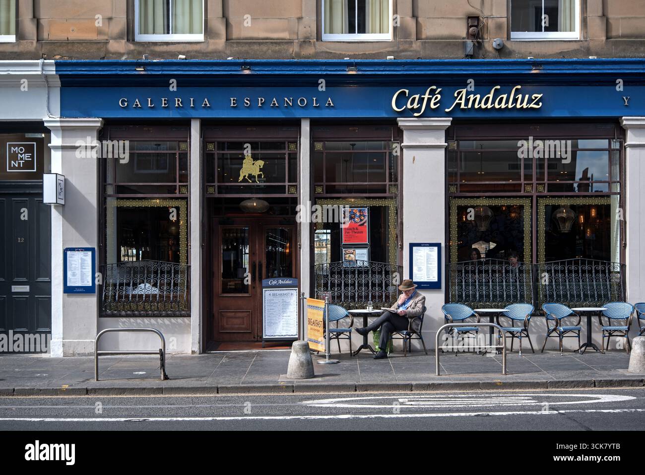 Gentleman readin the paper at a table outside Cafe Andaluz on George IV Bridge, Edinburgh, Scotland, UK. Stock Photo