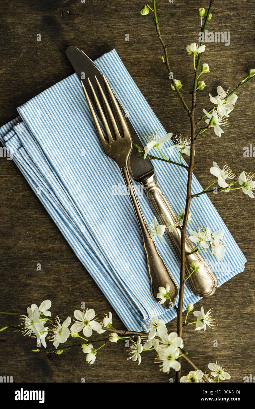 Feastive table setting for holiday Easter dinner decorated with blooming cherry flowers on rustic table with copy space Stock Photo