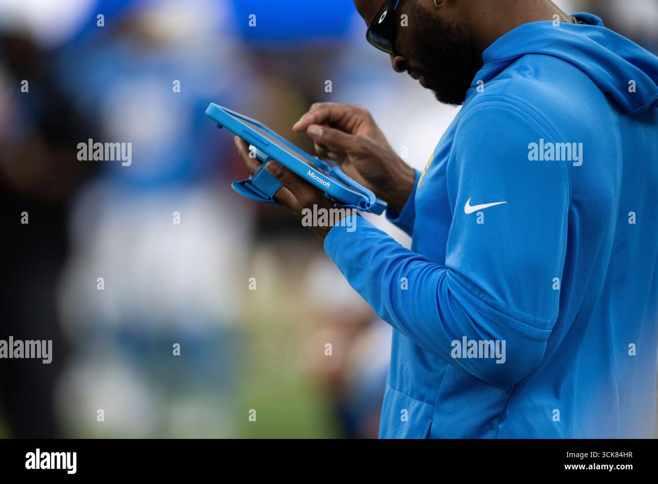 A Los Angeles Chargers player looks at a Microsoft Surface tablet