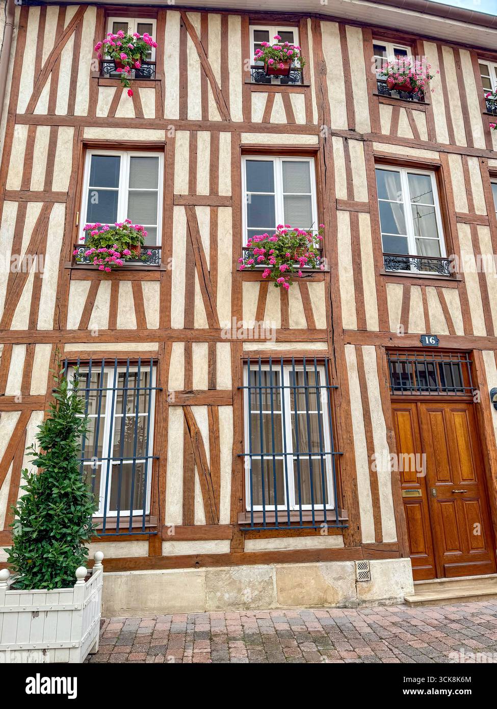 Charming traditional half-timbered house with flower boxes on a cobblestone street in chalons en champagne, france - Smartphone Captured Stock Image