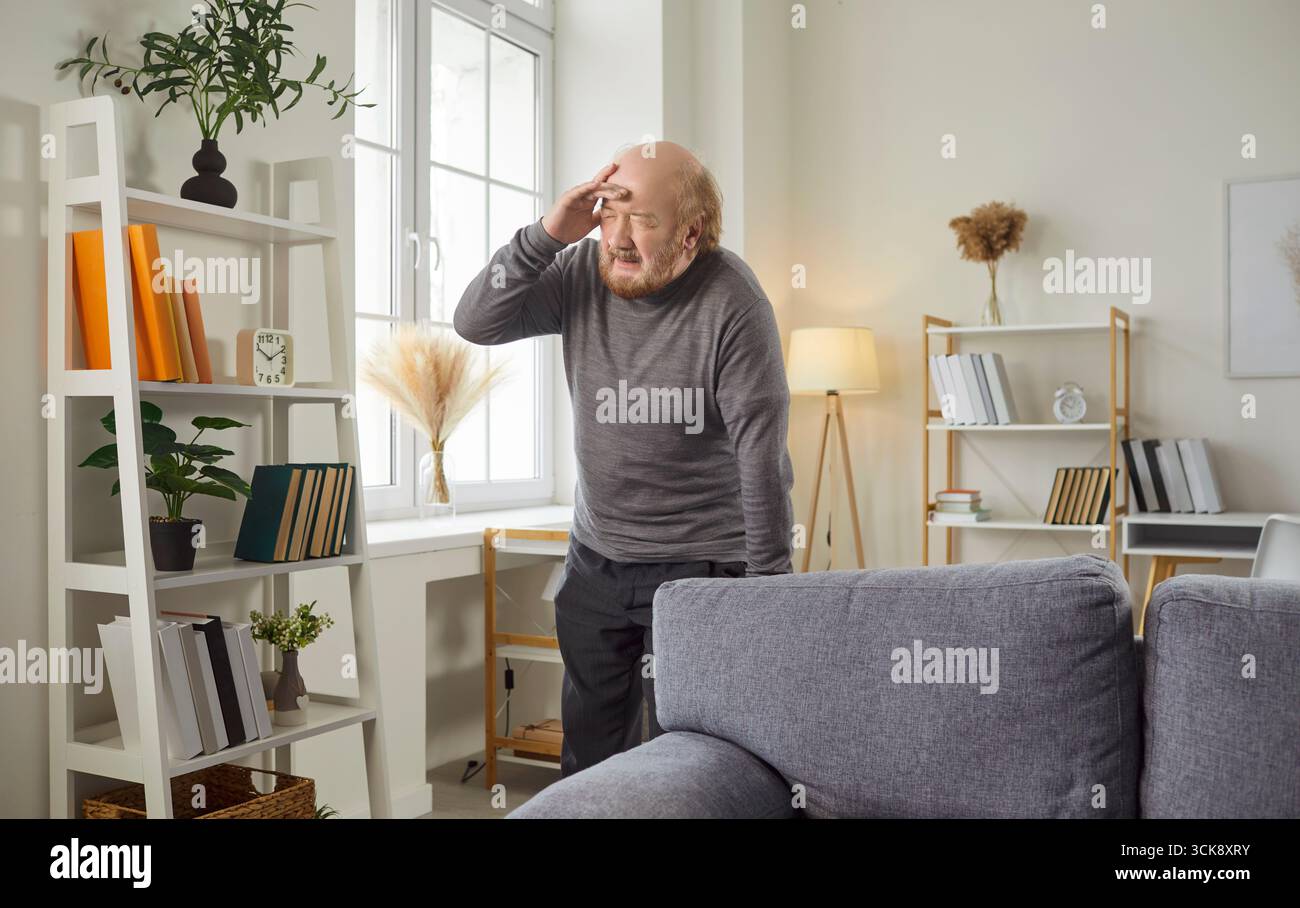 Sad Elderly Man Suffering From Headache At Home Stock Photo