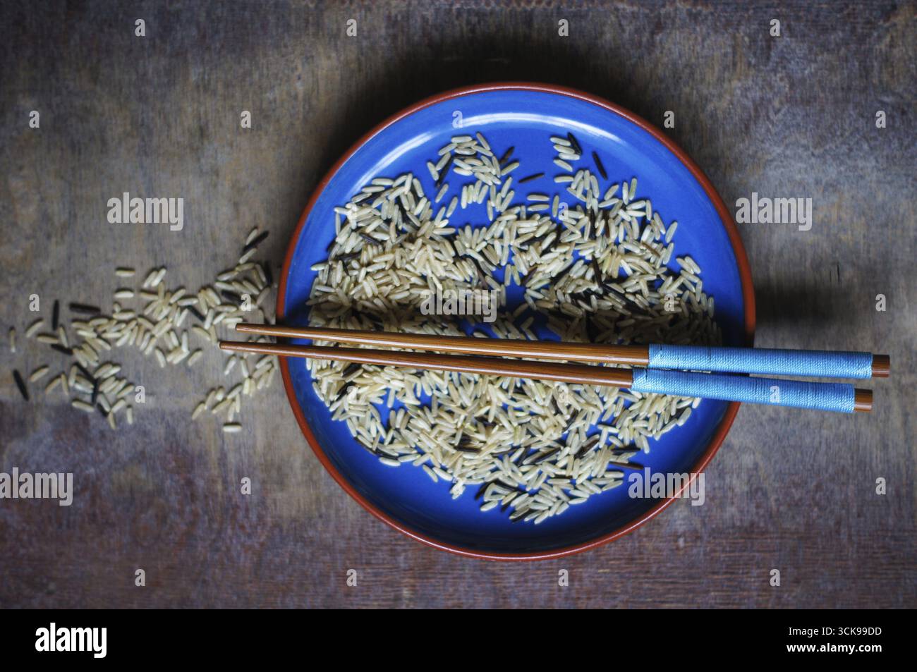 Bowl of rice with wooden chopsticks and a wood place mat Stock Photo