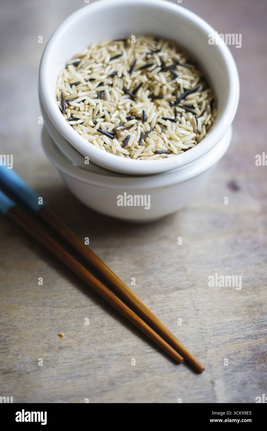 Bowl of rice with wooden chopsticks and a wood place mat Stock Photo