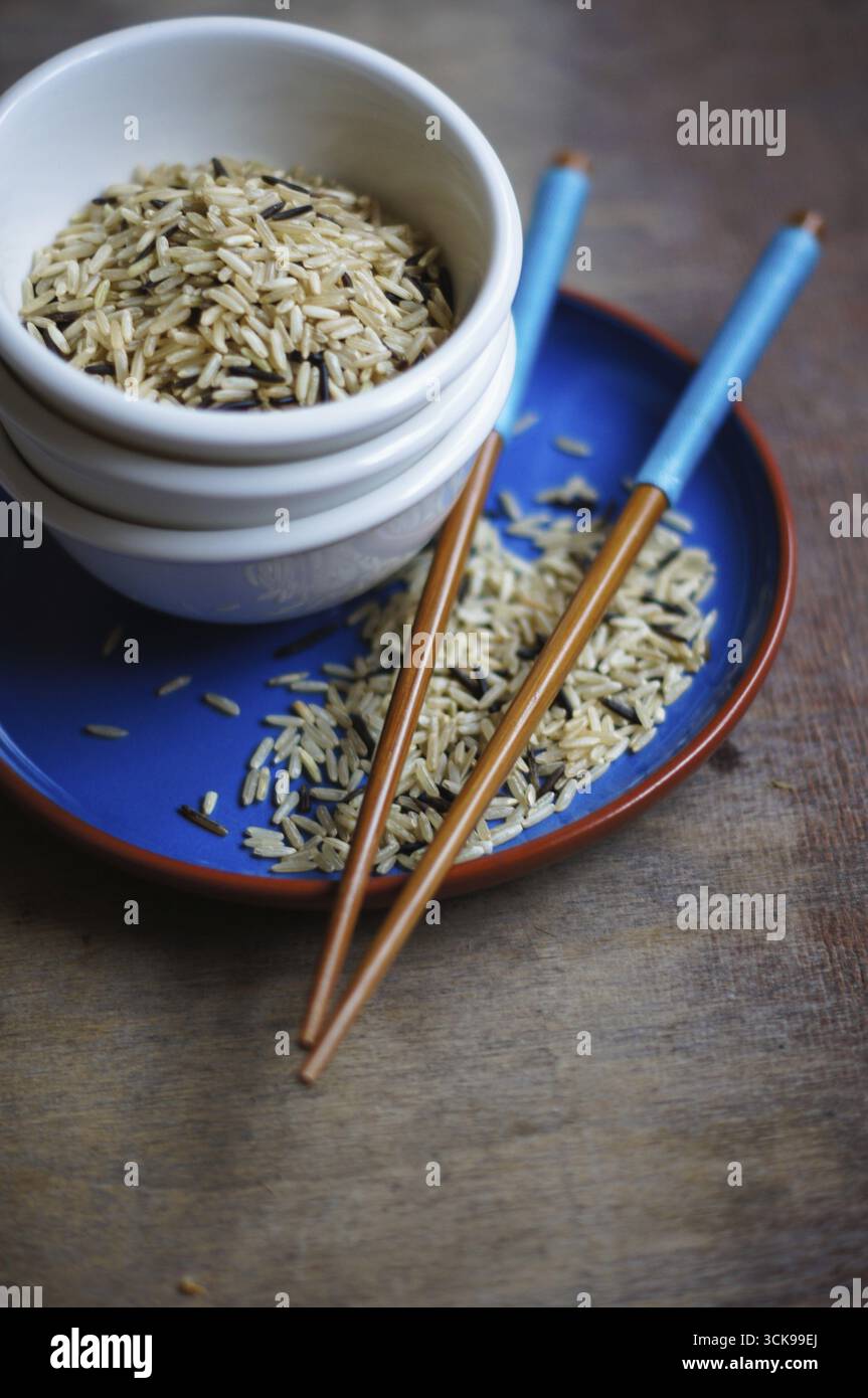 Bowl of rice with wooden chopsticks and a wood place mat Stock Photo