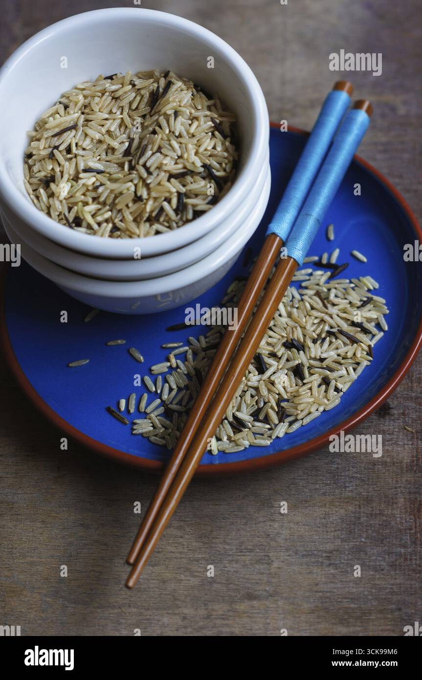 Bowl of rice with wooden chopsticks and a wood place mat Stock Photo