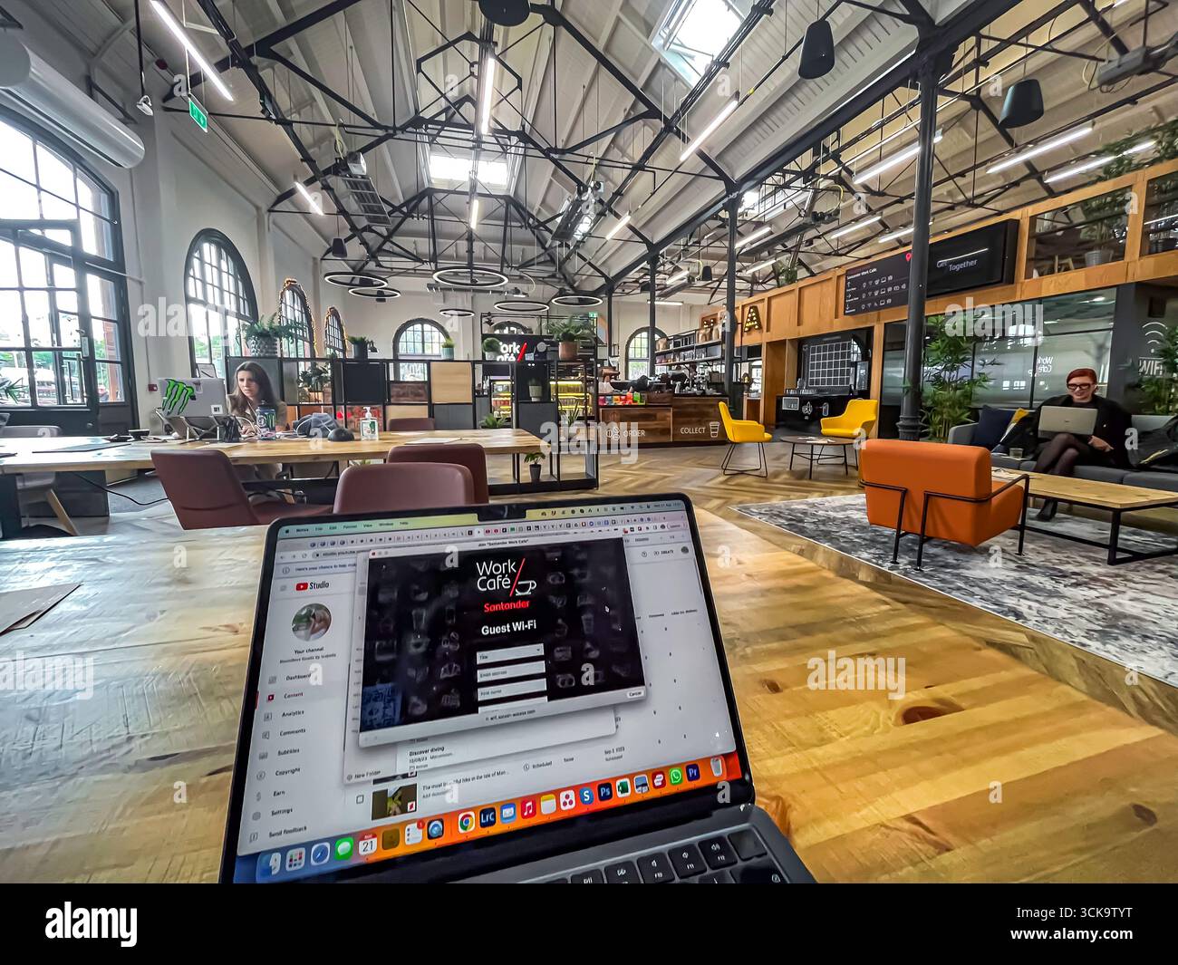Douglas, Isle of Man 08,05,2023 Laptop is open on a wooden table in a large room with a view of a ceiling. The laptop is displaying a video game calle Stock Photo