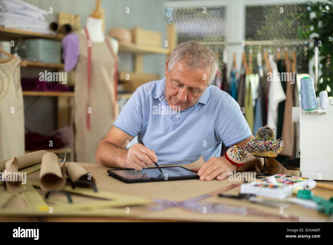 Man tailor makes pattern using tablet Stock Photo