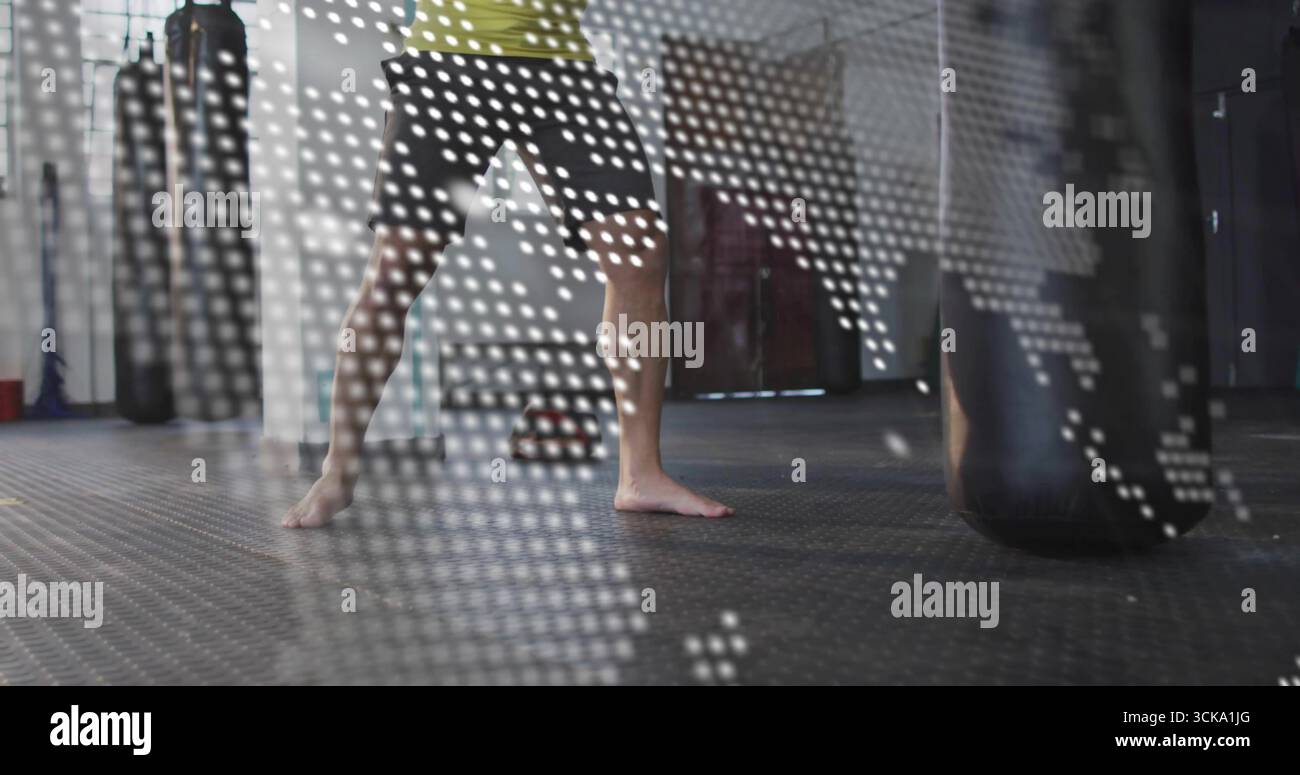 Holding man in green shirt performing fighting stance in gym, with punching bag, world map overlay Stock Photo