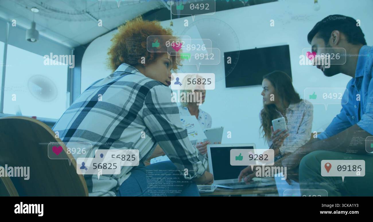 Collaborating four professionals analyzing social media metrics in office using laptop smartphone Stock Photo