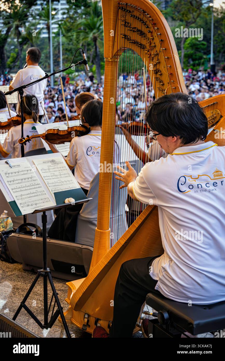 Musicians on stage playing in open air classical music concert in Lumphini Park, Bangkok, Thailand Stock Photo