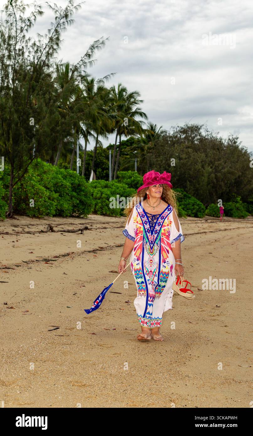 lady walking beach with australian flag  colour full dress long curly brown hair 50 plus models mature models modelling australia australian Stock Photo