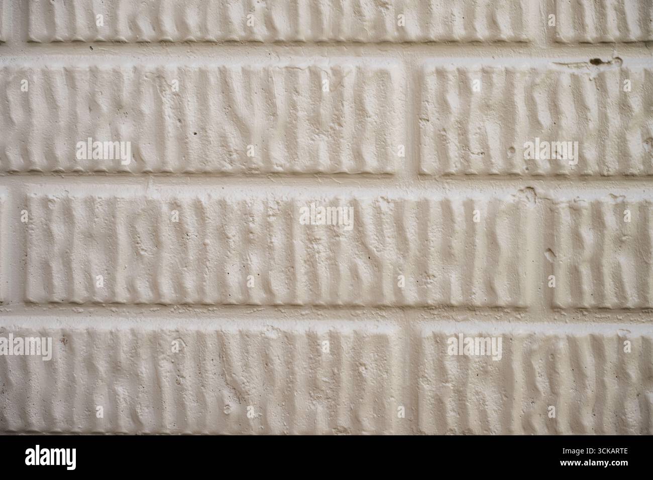 View of Textured white brick wall with a unique pattern seen up close in a well ...