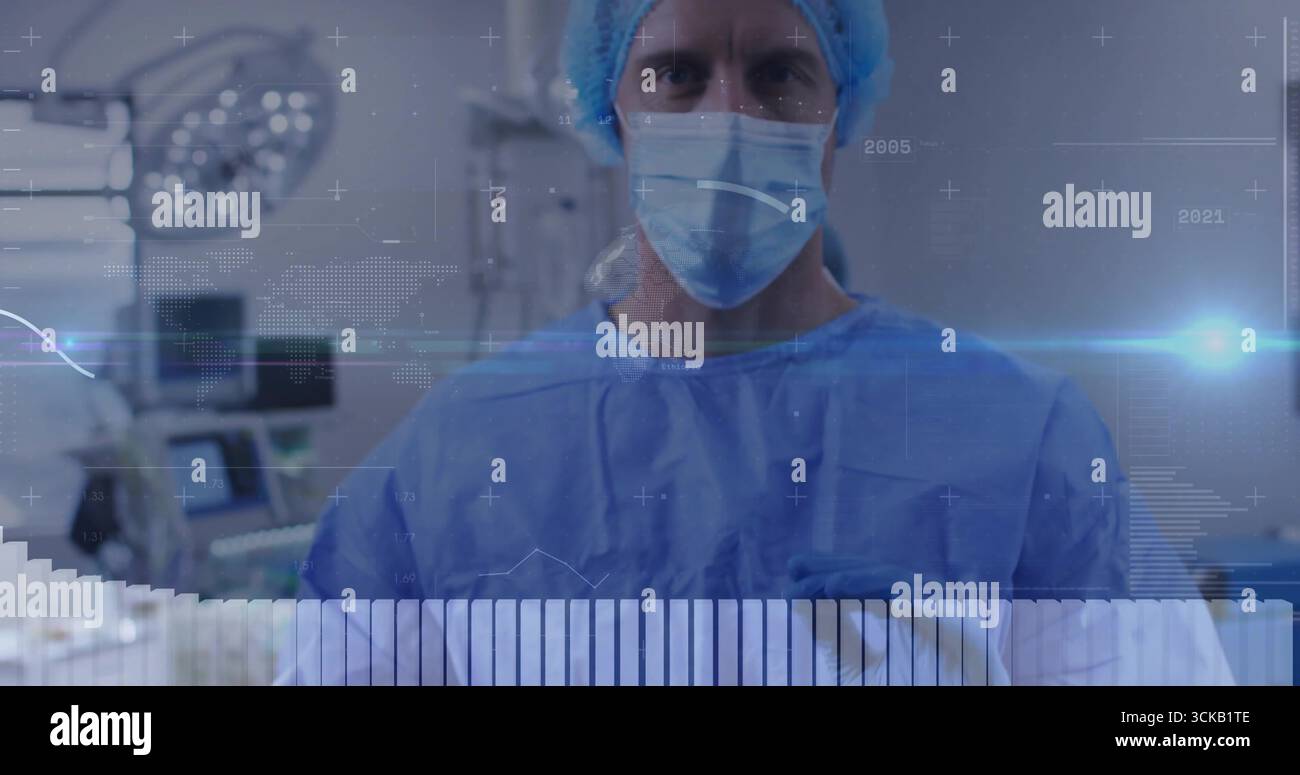 Surgeon Using Monitor Standing male surgeon wearing blue gown and mask in operating room ...