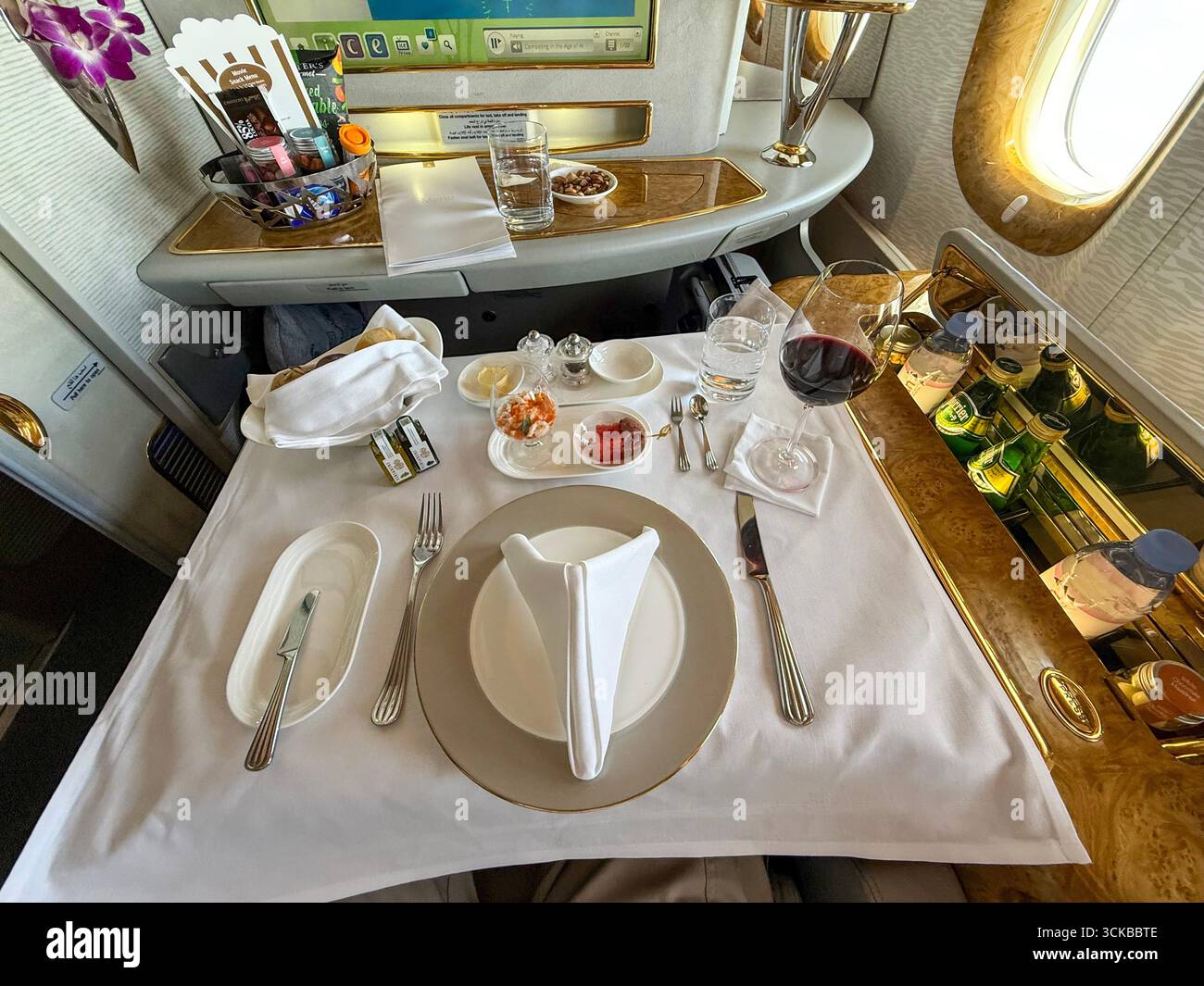 A ‘silver service’ table set for lunch on board a Boeing 777 self-enclosed 1st class cabin with enough room to add 2 or 3 economy seating. - Smartphone Captured Stock Image