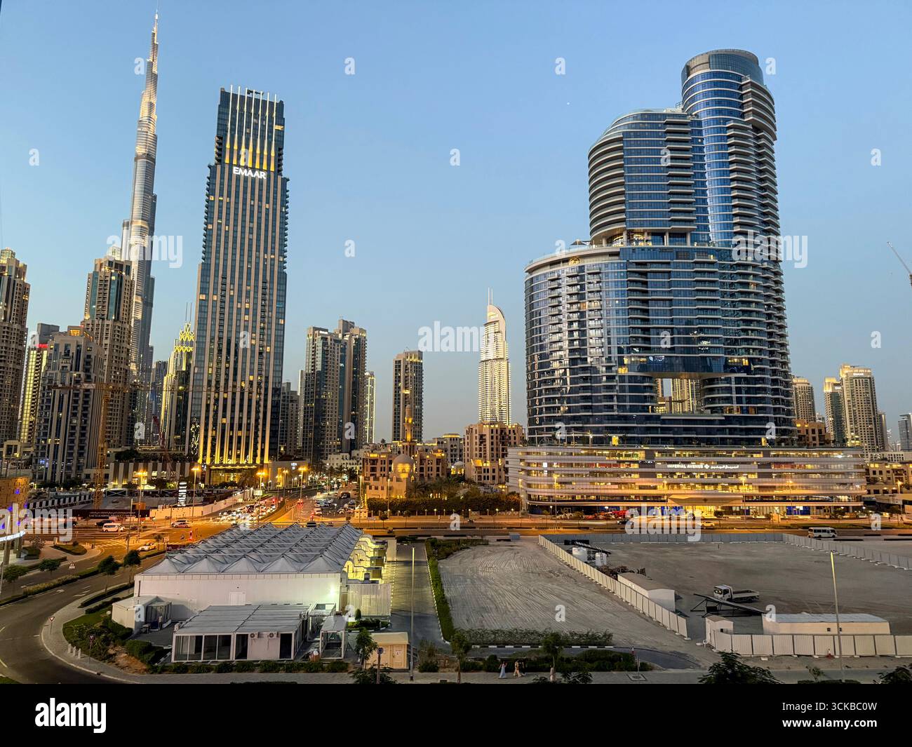 As the sun sets, the lights come to life over downtown Dubai in the United Arab Emirates.  The skyline of the thin- shaped well-known Burj Khalifa tow - Smartphone Captured Stock Image